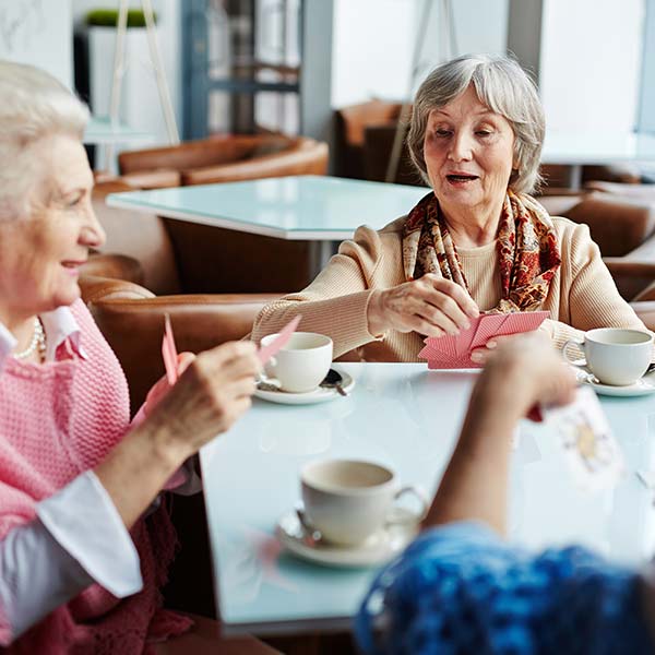 Elder women playing cards on the coffee table